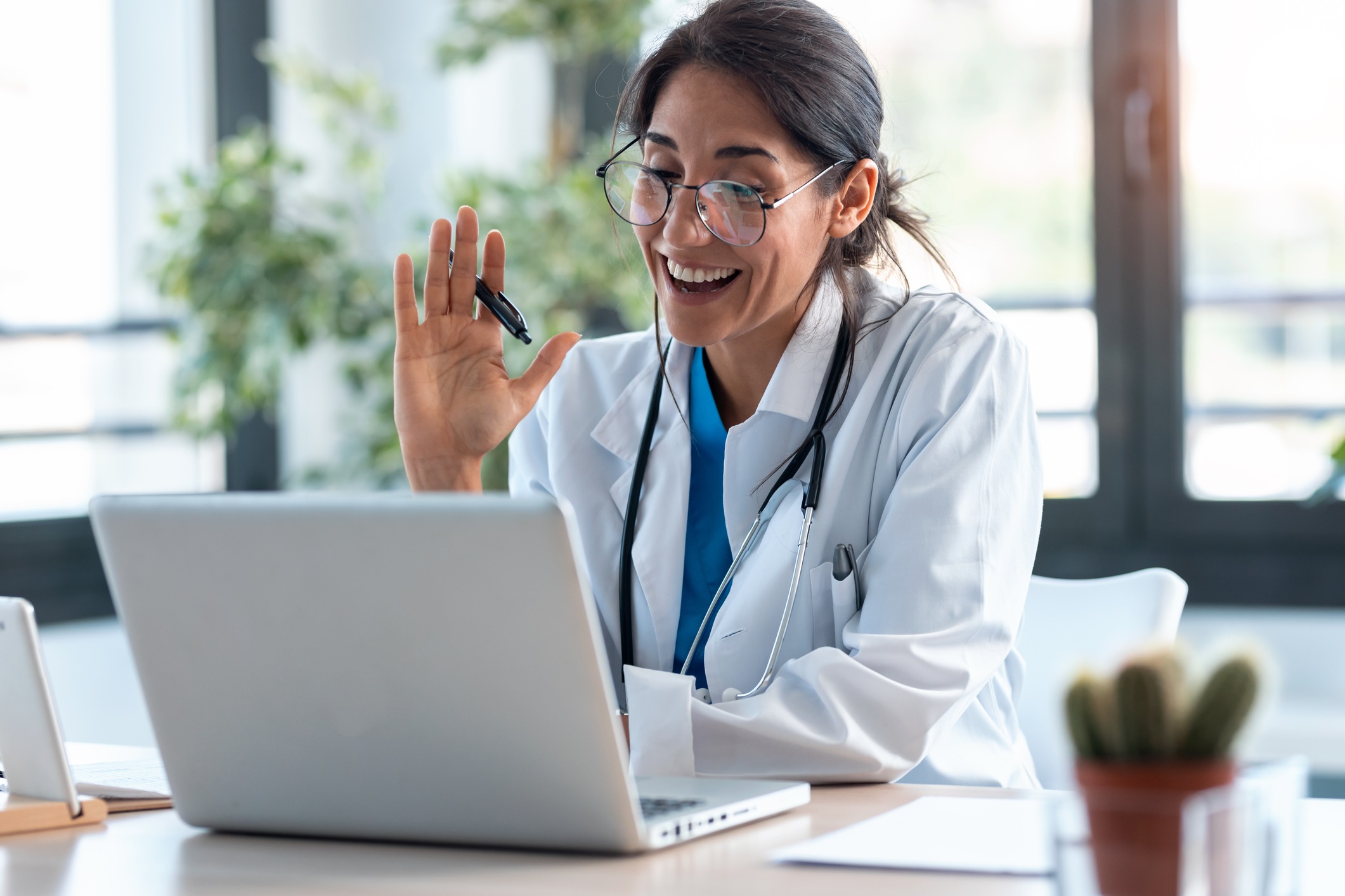 female provider waves to computer screen during a videoconferencing session