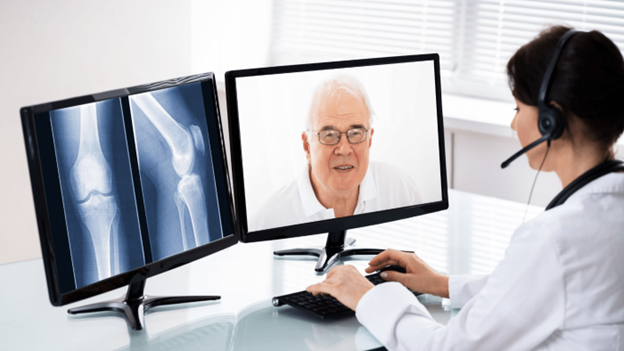 A doctor viewing an x-ray while video calling an older man.