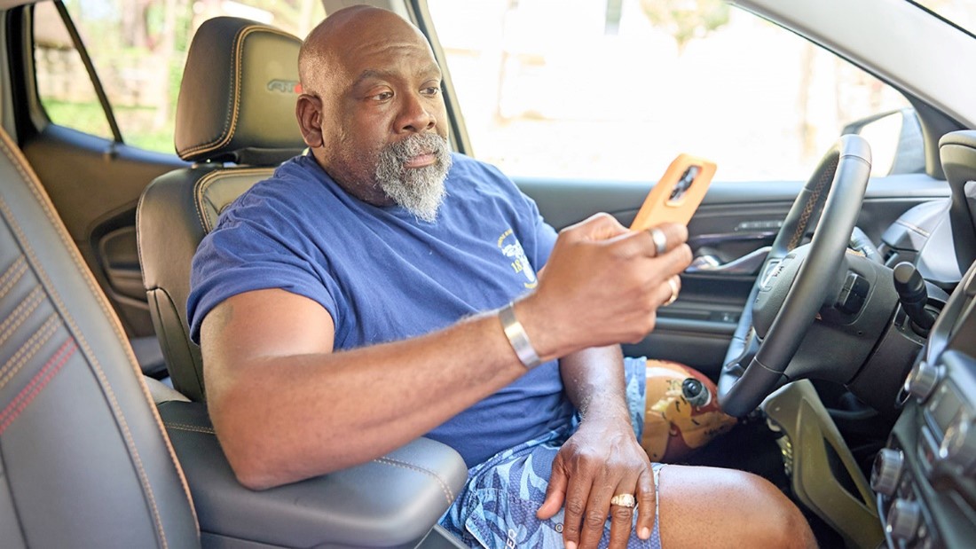 A man with a prosthetic leg checking his phone. 