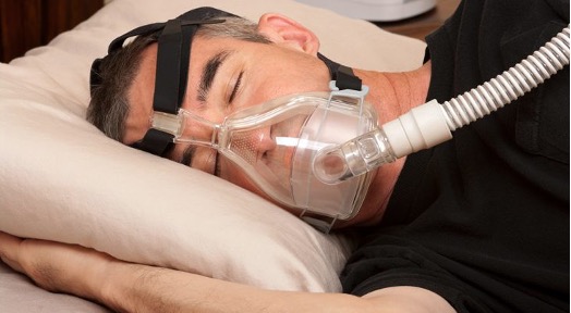 man sleeping with apnea machine