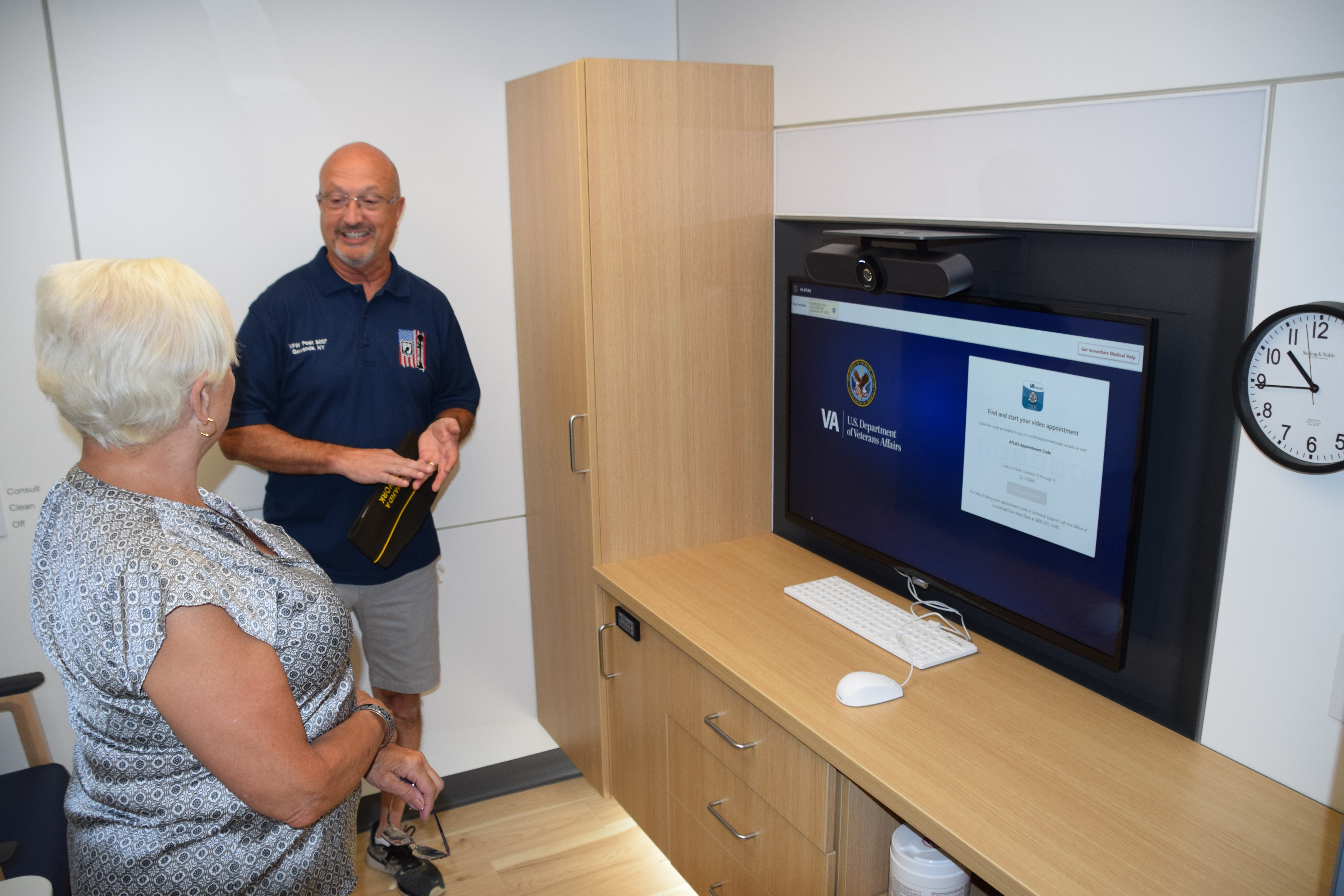 Telehealth appointment space including large screen and console for video visits