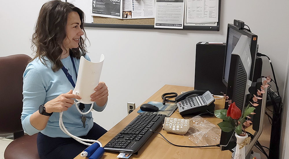 Occupational Therapist Kristen Wingate smiling and looking at computer screen