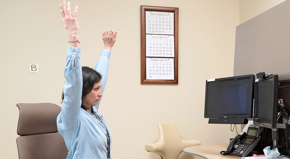 Woman demonstrates physical therapy stretch on video 