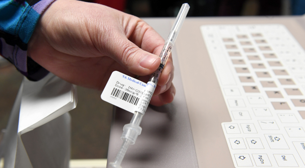 hand holding a vaccine needle 