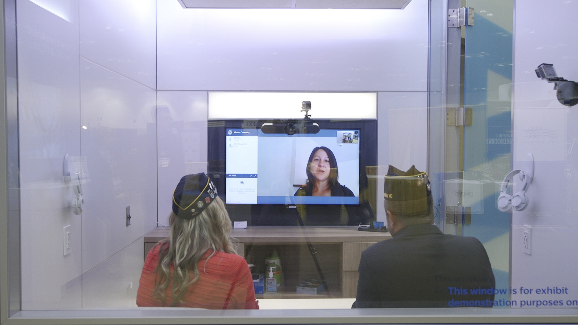 A man and a women face a monitor with a provider on screen