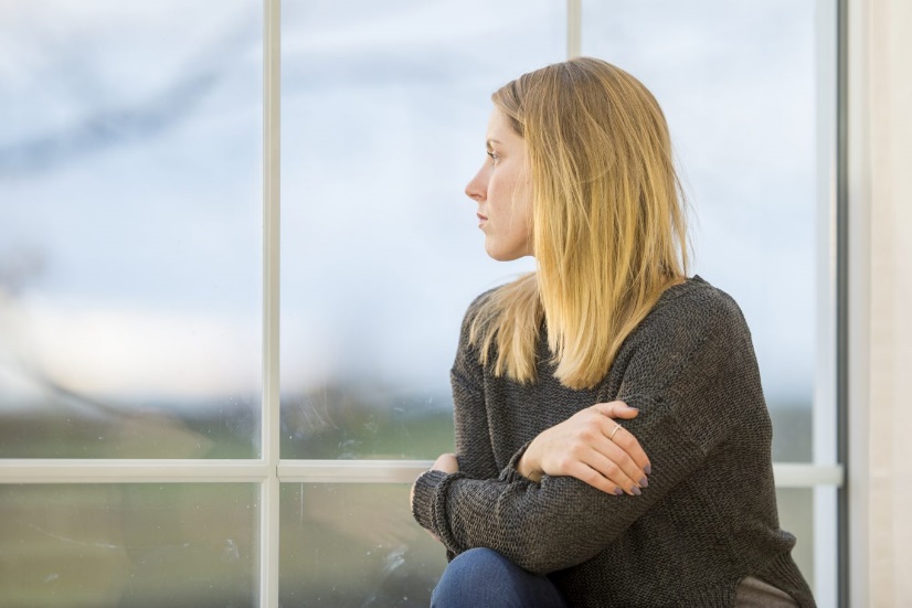 Woman sitting at window and looking outside