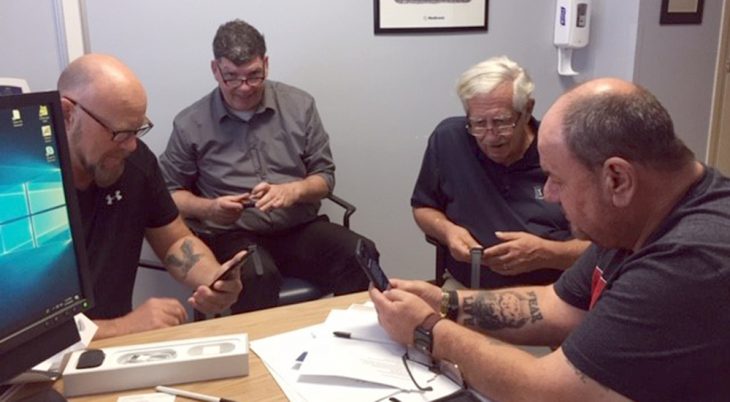 Veterans around a table are using their smartphones