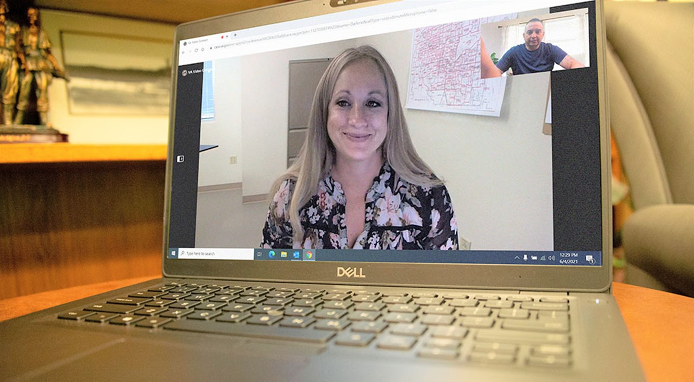 Women with blond hair smiles on the screen of a computer 