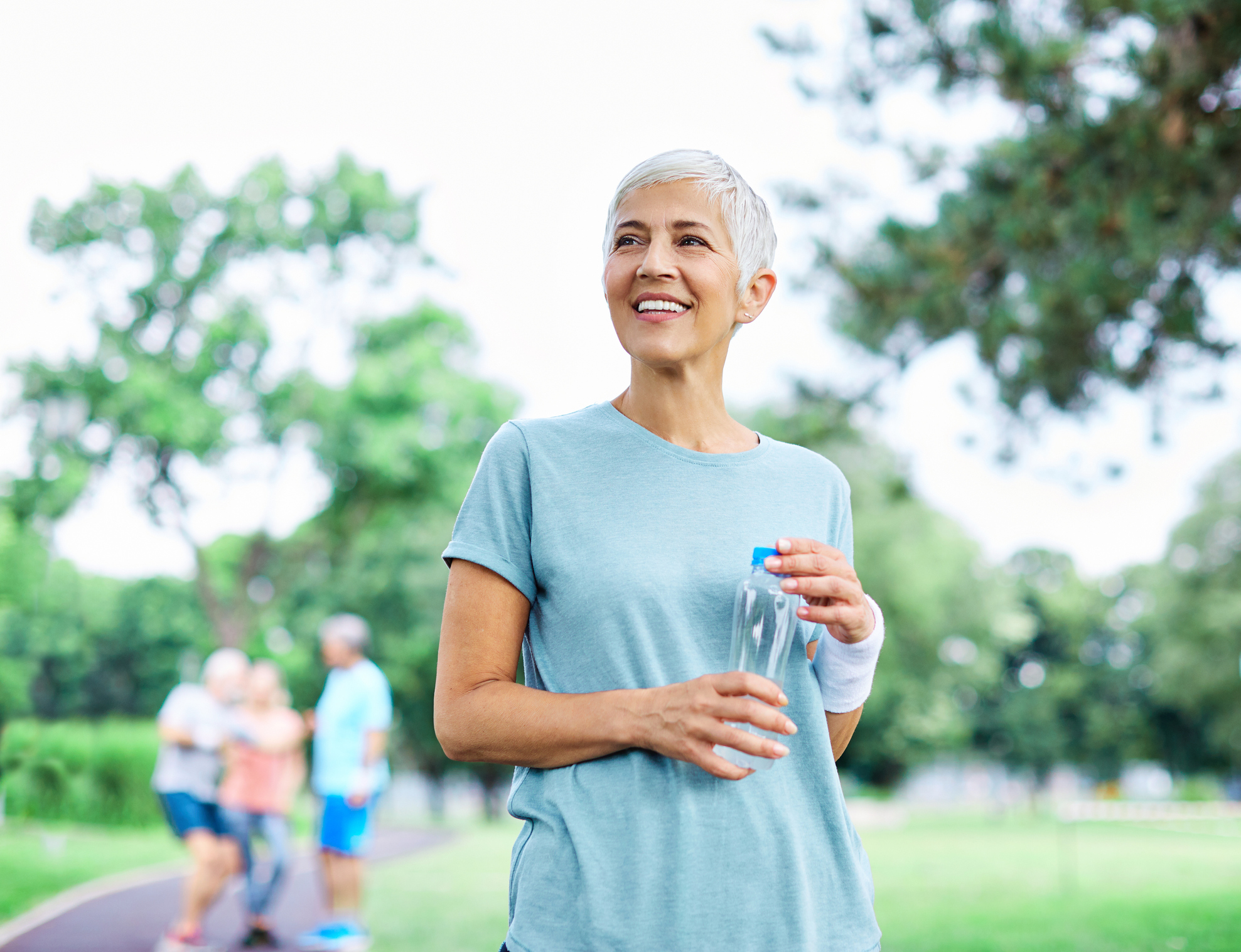 A woman exercising and holding a water bottle. 