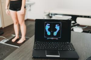Adult stands on scale and image of feet is on computer screen.