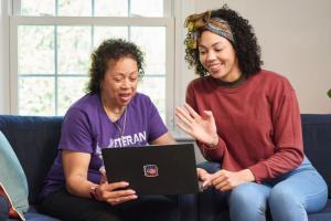 A Veteran and a caregiver joining a virtual call on a laptop. 