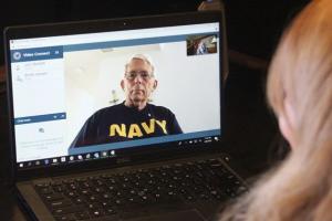 Navy Veteran on computer screen, speaking to woman provider by video 