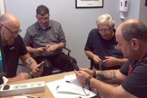 Veterans around a table are using their smartphones