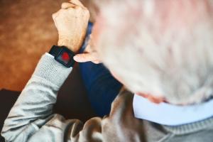 Older man looks at smart watch for heart reading