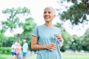 A woman exercising and holding a water bottle. 