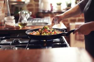 A photo of someone cooking vegetables in a pan.