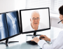 A doctor viewing an x-ray while video calling an older man. 