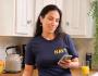 A woman wearing a U.S. navy shirt checking her smart phone.