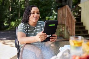 Woman with curly hair holds tablet